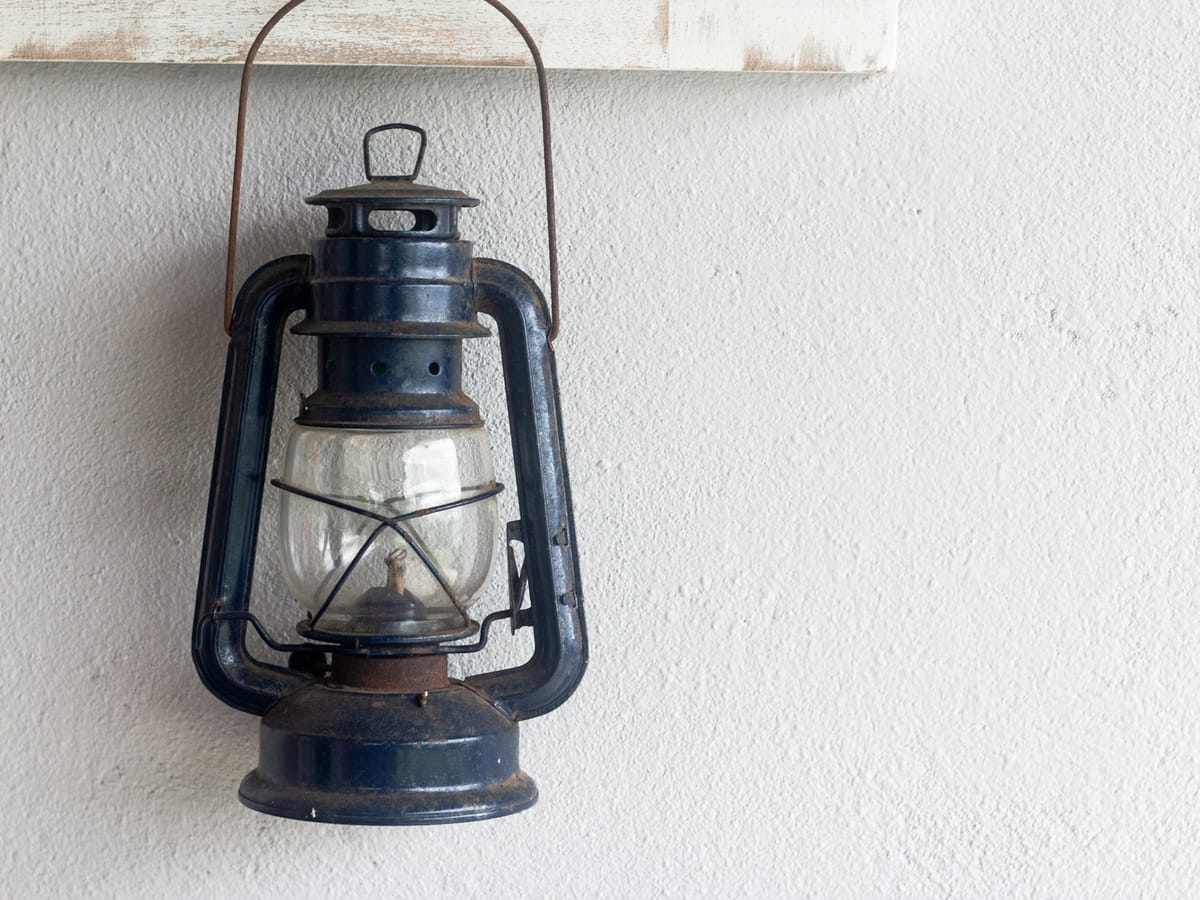 An old lantern hanging on a white wall